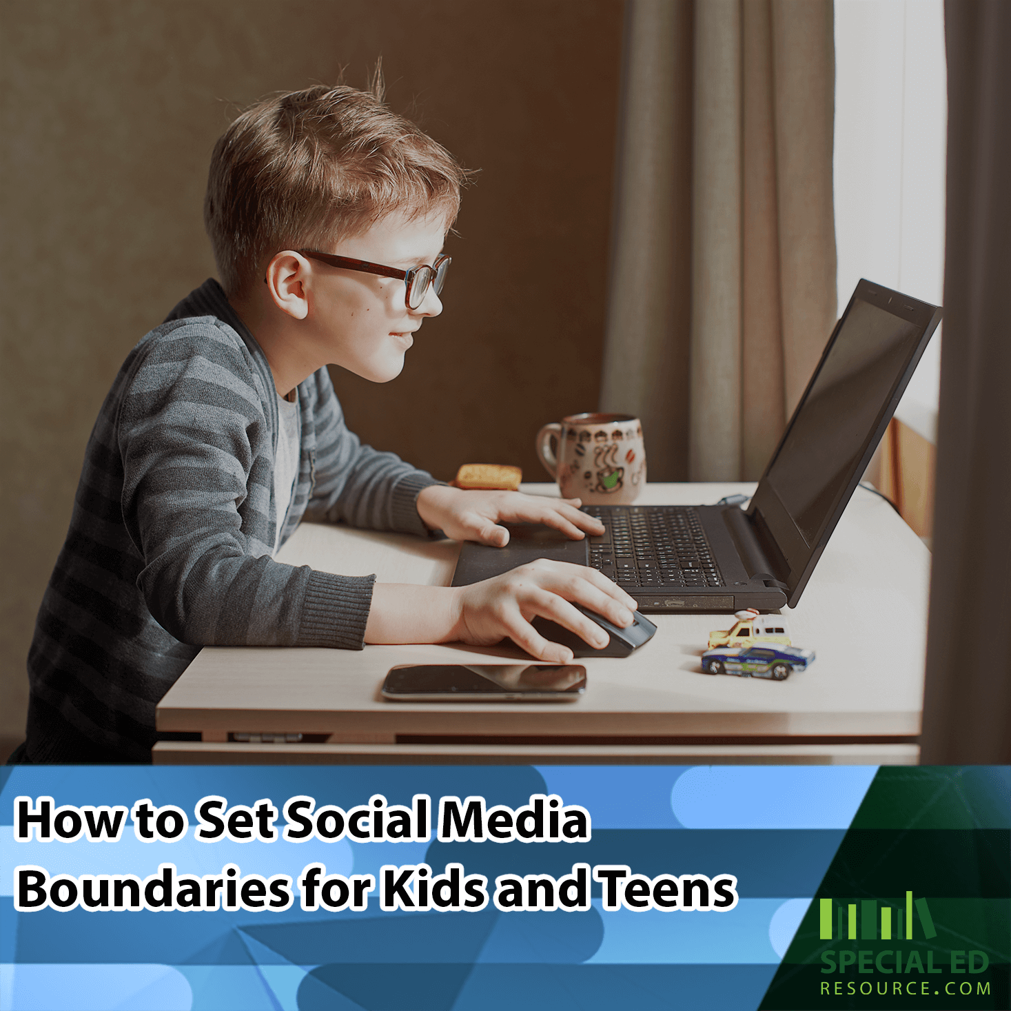A young boy with glasses focused on using a laptop at a desk, with a mug and smartphone nearby, using the social media boundaries for kids his parents established from the tips in this blog post by https://staging.specialedresource.com/